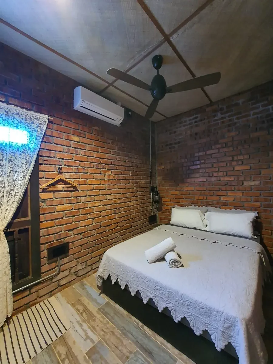 Queen bedroom with white bedding, lace curtain and lantern lamp