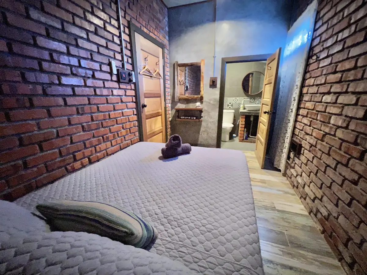 Queen bedroom with exposed brick and attached bathroom