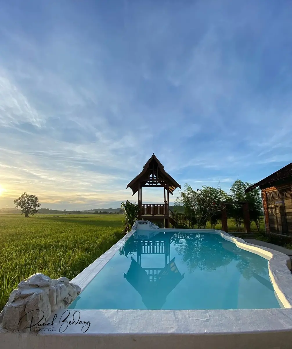 The infinity pool and gazebo at sunset