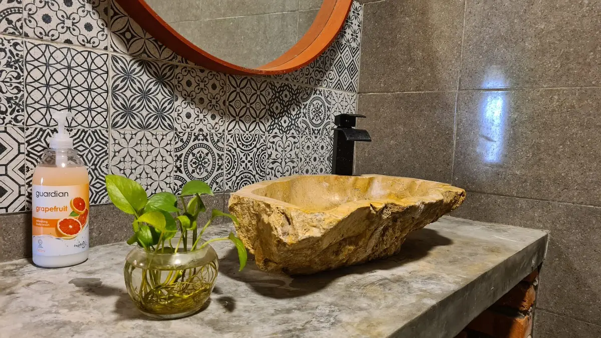 Carved natural stone basin with Peranakan-style patterned tiles