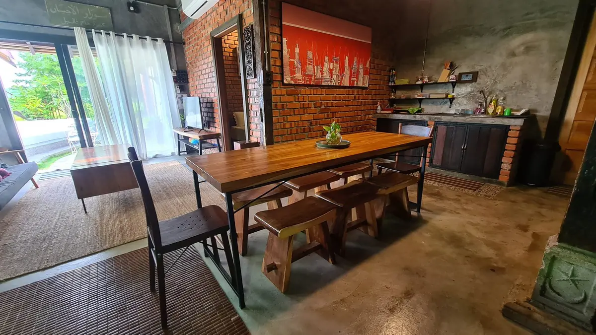 Long teak dining table for the whole family beside the kitchen